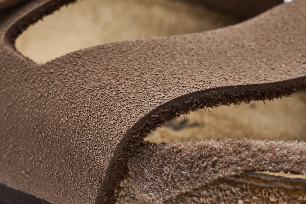 Close-up of a mocha Birkibuc Birkenstock strap showing the matte, nubuck-like texture